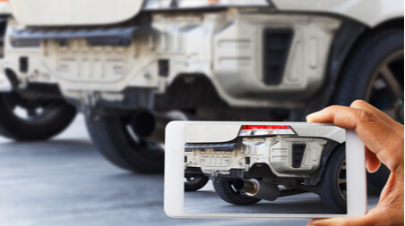 A person taking photos of a truck for evidence. 