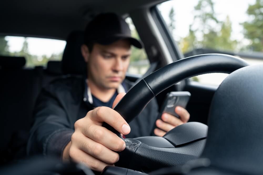 Distracted driver is texting while driving.