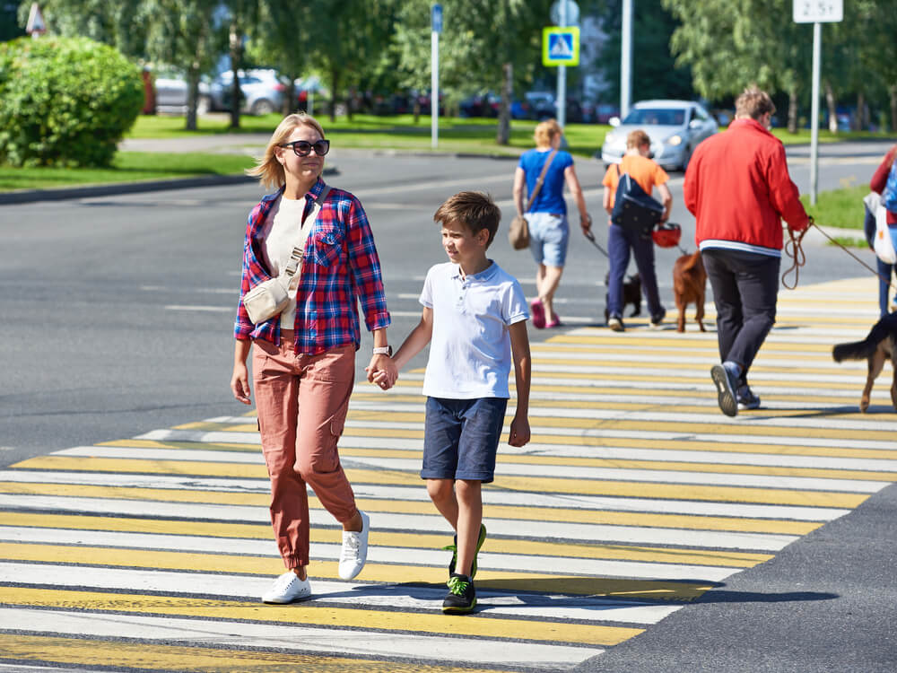 Mother and her kid crossing the pedestrian lane.