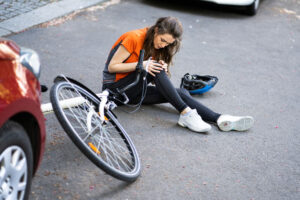 Biker girl got hit by a car suffering injuries.